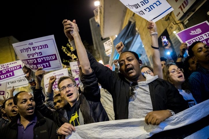 מסתננים עם פעילי שמאל בהפגנה. צילום: יונתן סינדל, פלאש 90