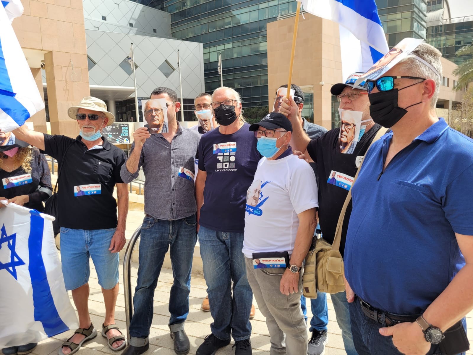 מפגינים במסכות של אריה שיף מחוץ לאולם המשפט