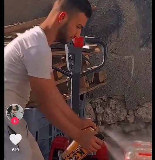 הפועל מרסס קוטל ג'וקים על פחיות הקולה. צילום: לפי נוסח 27א לחוק זכויות יוצרים