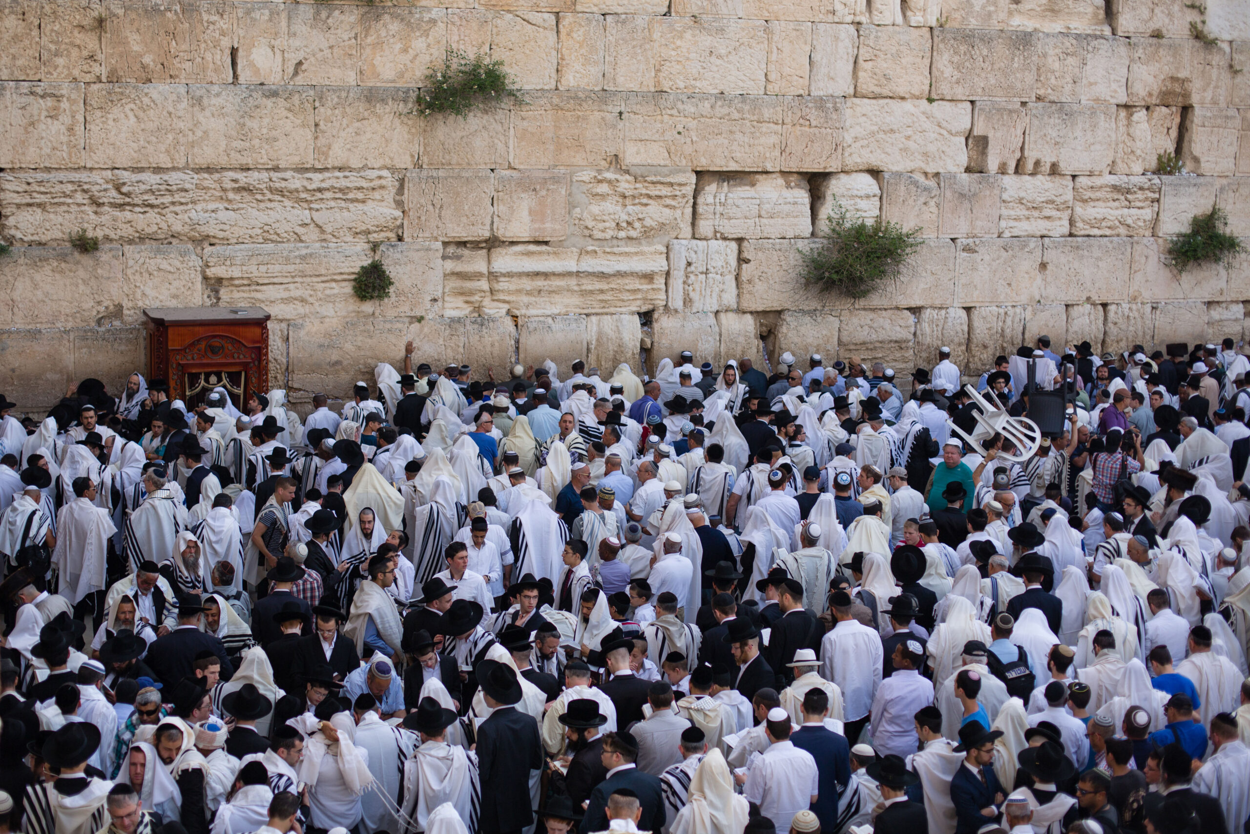 מתפללים יהודים מתכסים בטליתות בזמן שהם מתפללים מול הכותל המערבי, אתר התפילה הקדוש ביותר ביהדות, בעיר העתיקה בירושלים, במהלך ברכת כהן בחג הפסח היהודי, המנציח את יציאתם החפוזה של בני ישראל ממצרים. 25 באפריל, 2016.