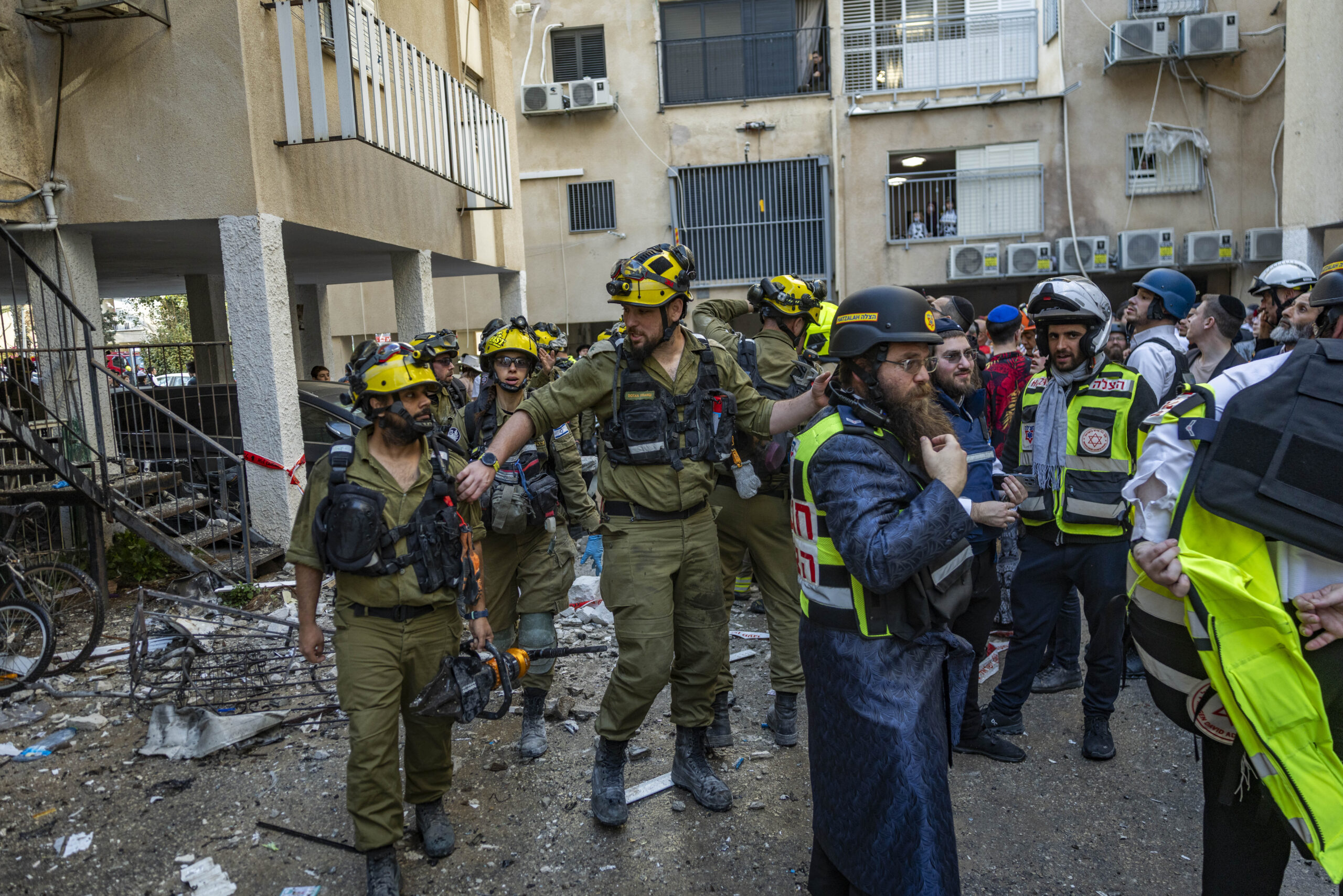 אזרחים וכוחות ביטחון והצלה ישראליים בזירה בה ניזוק בניין מגורים מרסיסי טיל בליסטי שנורה מאיראן בבני ברק, 3 במרץ 2026. צילום: חיים גולדברג/Flash90