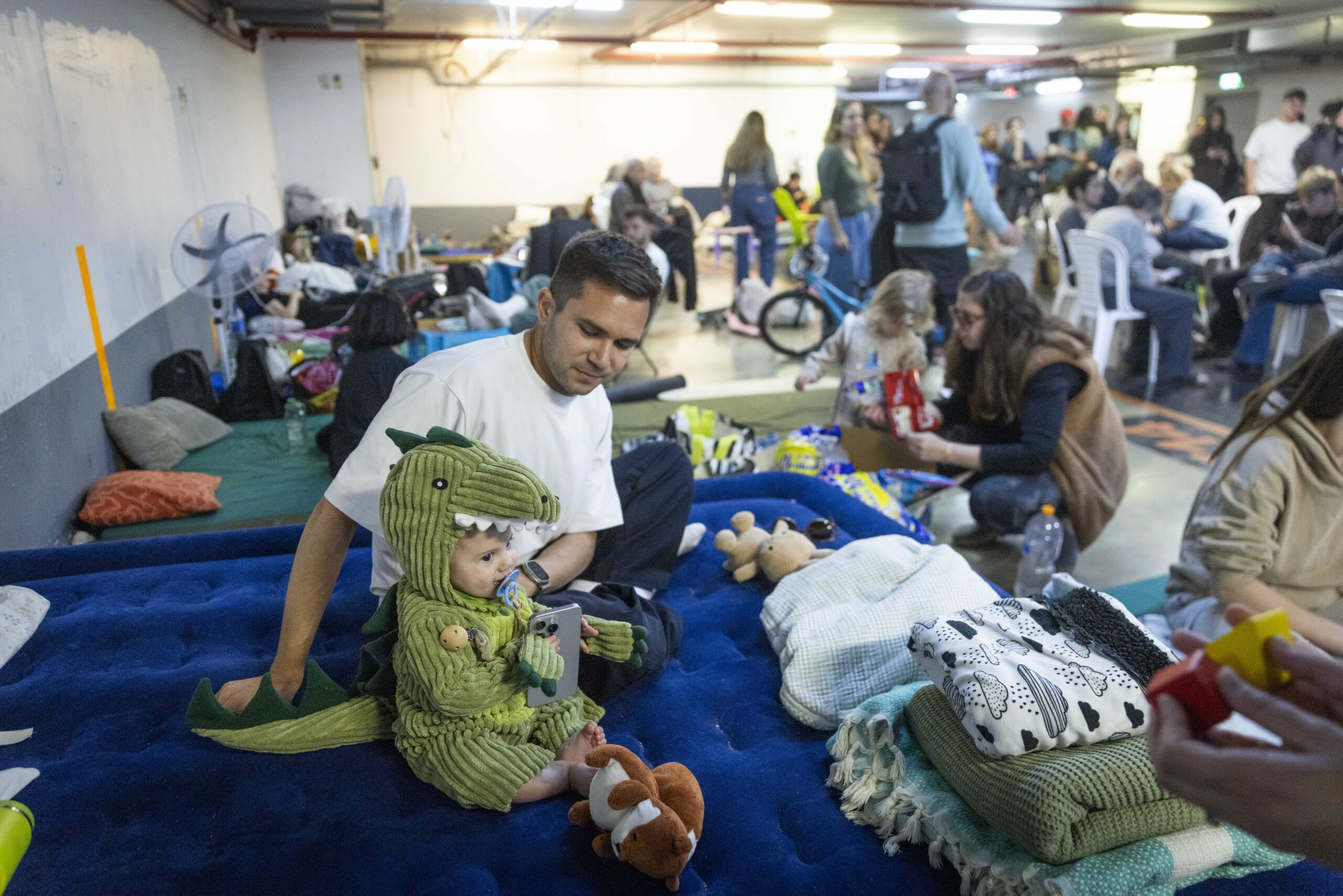 אנשים תופסים מחסה בחניון מתדרדר מפני טילים שנורו מאיראן, בתל אביב, 3 במרץ 2026. צילום: חיים גולדברג/Flash90 *** כיתוב מקומי *** תל אביב
